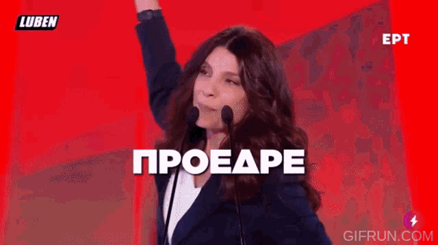 a woman speaking into a microphone with the words proeaape eaa on the screen