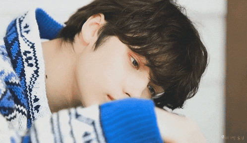 a close up of a person wearing a blue and white sweater with the letter n on it