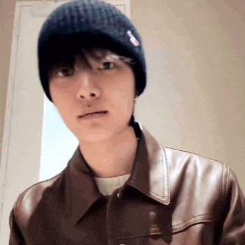 a man wearing a black beanie and a brown jacket