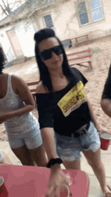a woman wearing sunglasses and a shirt with a license plate that says shawn