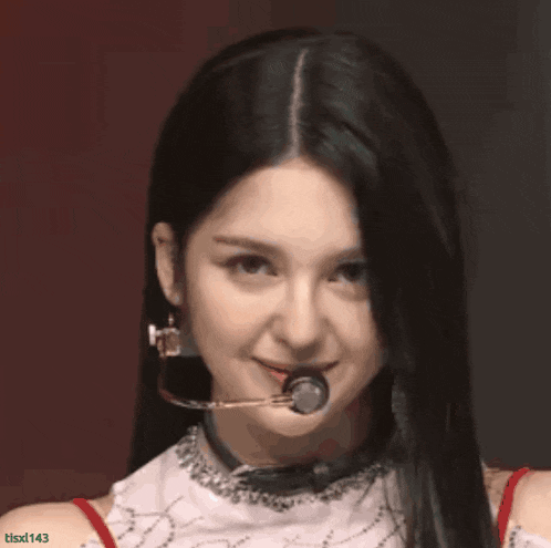 a close up of a woman 's face with a microphone in her mouth .