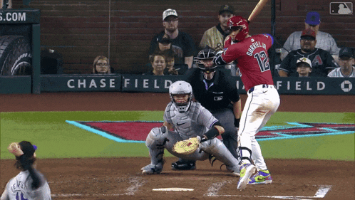 a baseball player with the number 12 on his jersey swings at a pitch