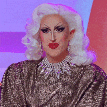 a drag queen with white hair and a necklace