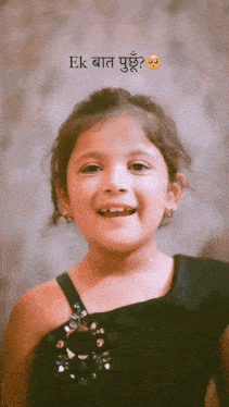 a little girl wearing a black dress is smiling with the words ek baat written above her