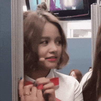 a girl in a white shirt with a red bow tie is smiling