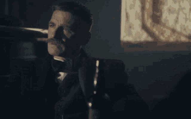 a man in a tuxedo is holding a glass with the word -fook written on it