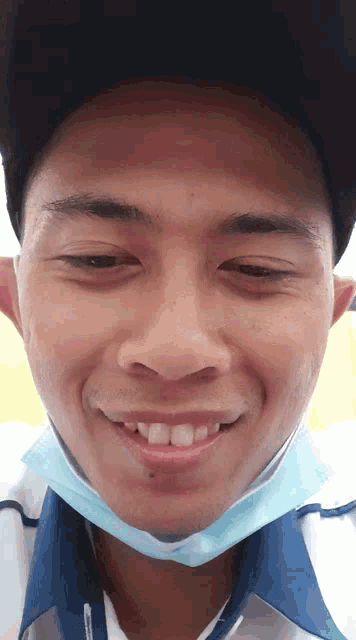 a man wearing a mask and a hat smiles