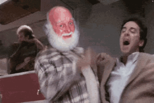 a man with a beard is standing next to another man with his mouth open .