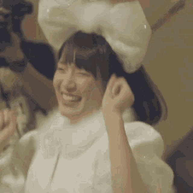 a woman wearing a white bow on her head