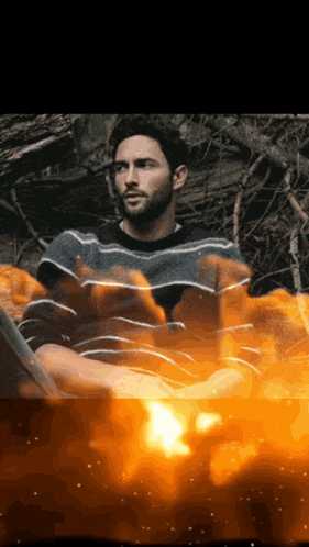 a man in a striped sweater sits in a fire