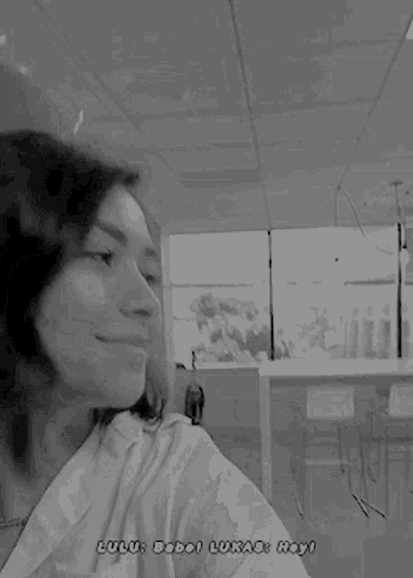 a black and white photo of a man and a woman smiling and taking a selfie .