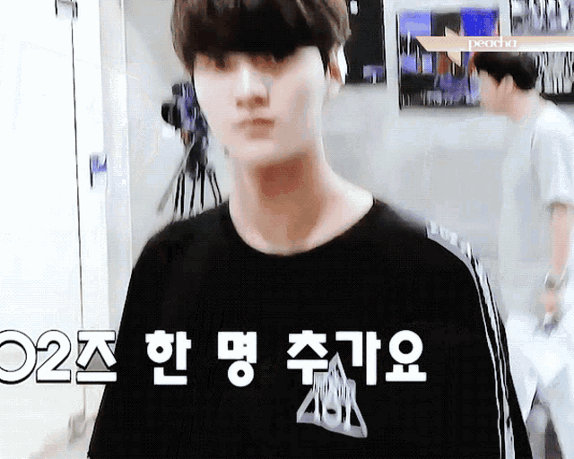 a man wearing a black shirt that says ' aoa ' on the front