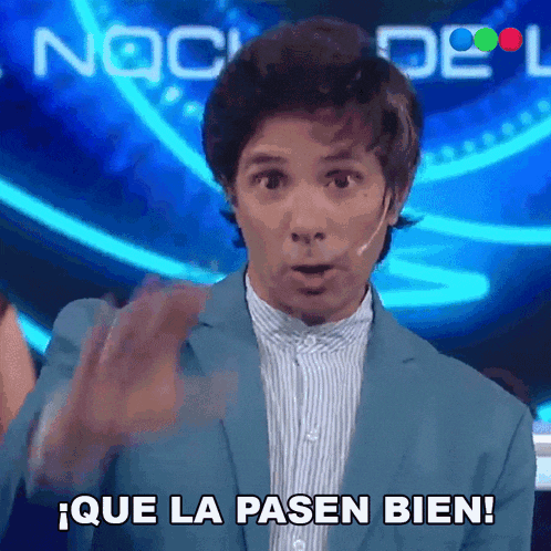 a man in a blue suit says que la pasen bien in spanish