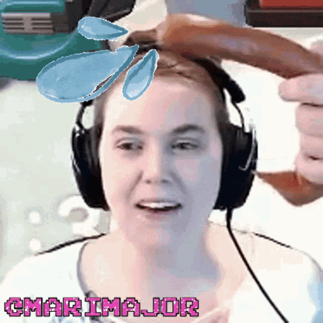 a woman wearing headphones is holding a sausage in front of her head and the word cmarimajor is on the bottom of the image