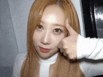 a woman with blonde hair is giving a thumbs up sign