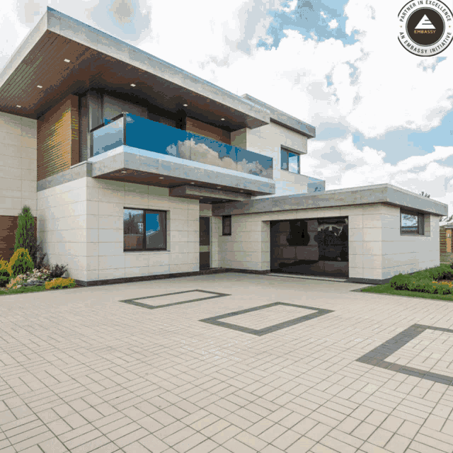 a large white house with a brick driveway and a sign that says " artisan in excellence "