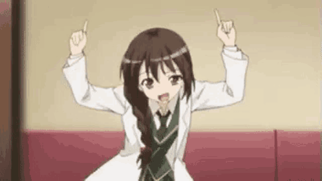 a girl is sitting on a couch with her arms in the air .