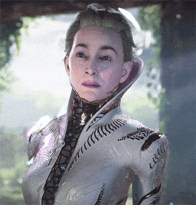 a woman in a futuristic outfit looks at the camera with a serious look on her face