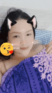 a woman wearing cat ears and a purple blanket