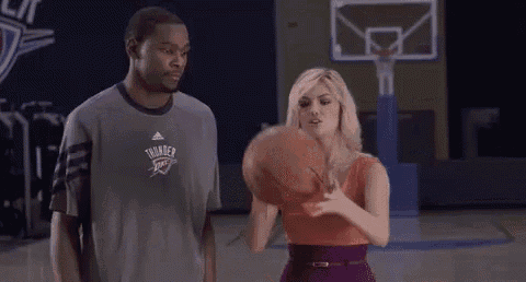 a man and woman are standing on a basketball court .