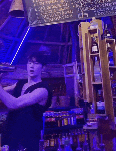 a bartender prepares a drink in front of a chalkboard that says gin tonic