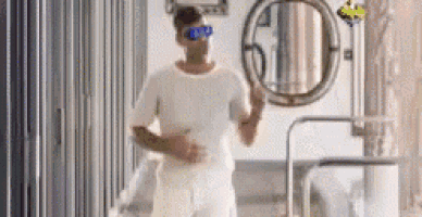 a man wearing sunglasses and a white shirt is running in a room .