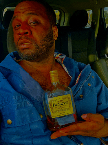 a man holding a bottle of hennessy cognac