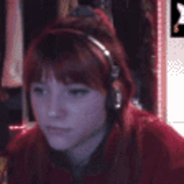 a girl with red hair wearing headphones and a red jacket
