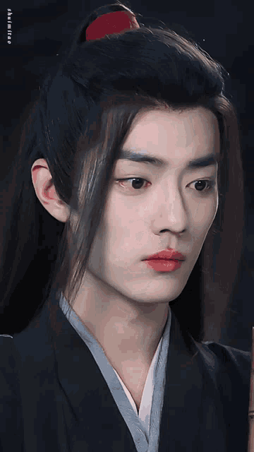a close up of a man 's face with a ponytail