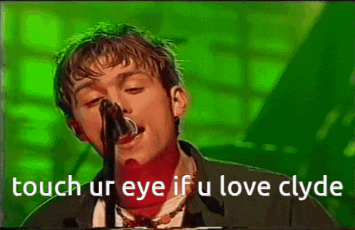 a man singing into a microphone with the words touch ur eye if u love clyde written below him