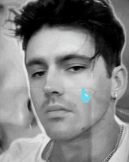 a close up of a man 's face with a blue tear coming out of his nose