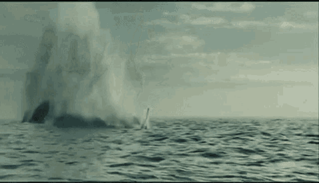 a large explosion in the ocean with smoke coming out of the water