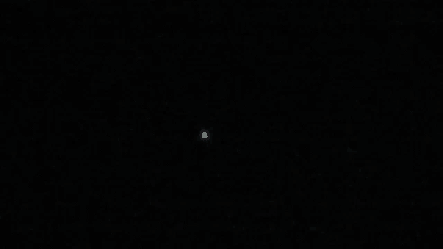 a small white object is visible in the dark sky