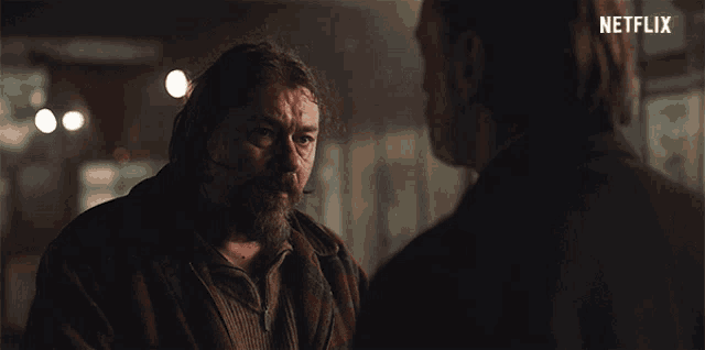a man with a beard is talking to another man with a netflix logo in the corner