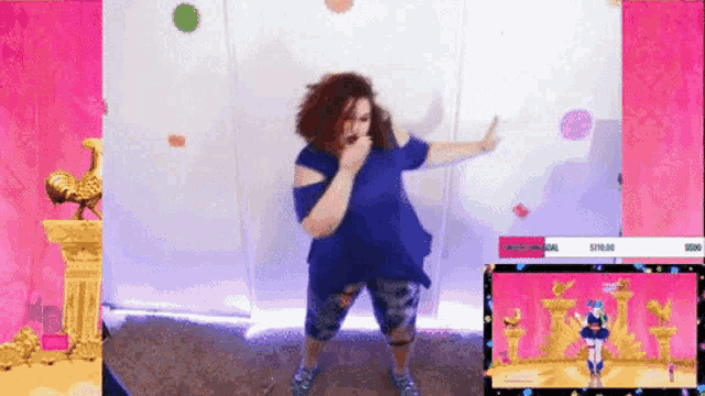 a woman in a blue shirt is dancing in front of a screen that says ' twitch ' on it