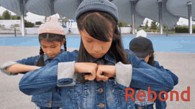 a girl in a denim jacket has the word rebond on her chest