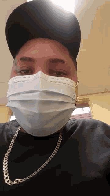 a man wearing a black hat and a white face mask
