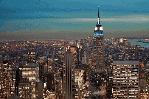 the empire state building is lit up at night in blue