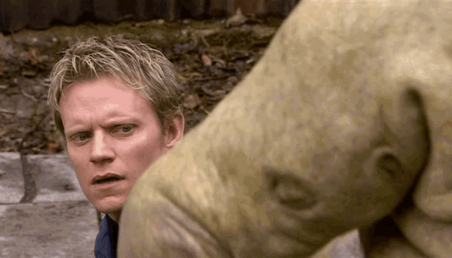 a close up of a man looking at a statue of a pig