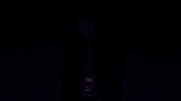a silhouette of a man standing in front of a pink wall