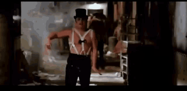 a man without a shirt is wearing a top hat and suspenders .
