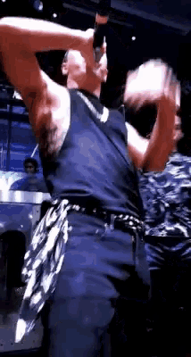 a man in a black tank top is holding a microphone
