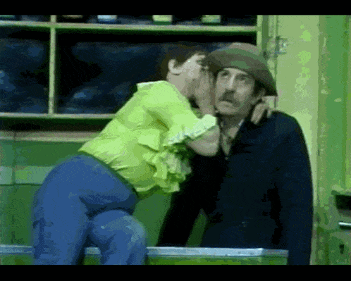 a woman is whispering into a man 's ear
