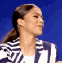 a close up of a woman wearing a striped jacket .