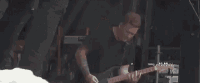 a man is playing a piano in a dark room with a lot of lights .