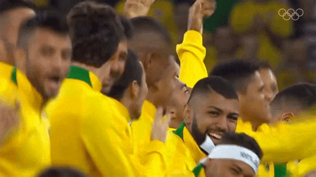 a group of men wearing yellow jackets are cheering and smiling