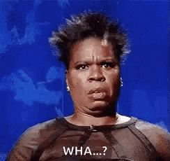 a woman in a black dress is making a funny face and says `` wha ...? '' .