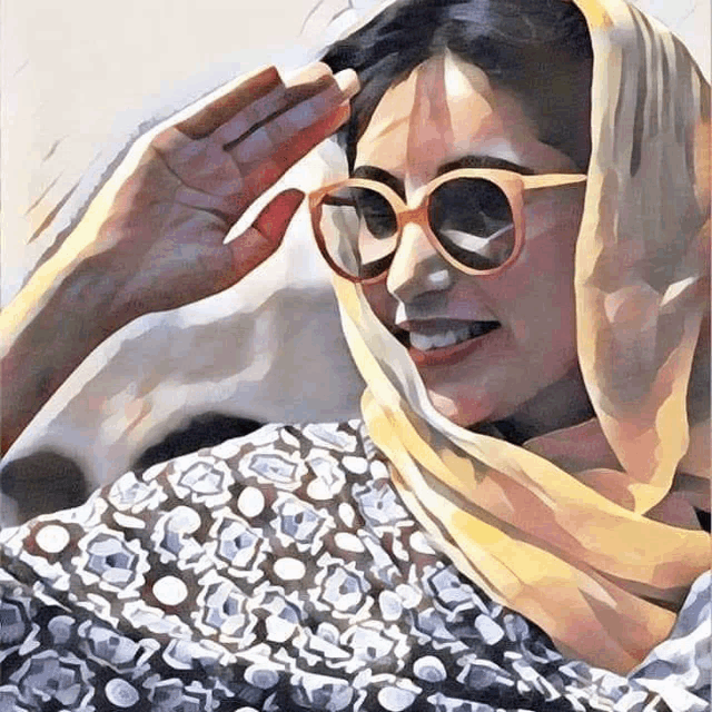 a woman wearing sunglasses and a head scarf is smiling