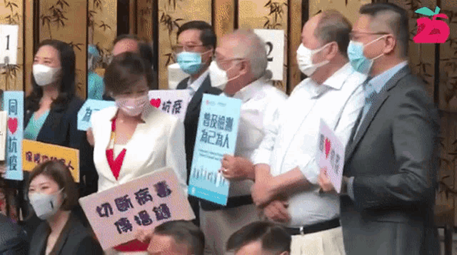 a group of people wearing face masks holding signs with chinese writing on them