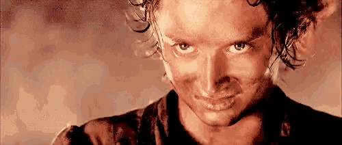 a close up of a man 's face with a dirty shirt on .